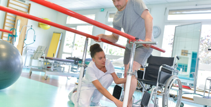 Occupational therapist helping patient to walk