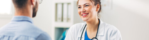 Woman Doctor talking to Patient at her Medical Office