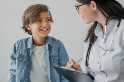 School boy and doctor have consultation in hospital room