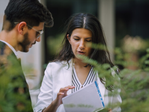 Businessman and businesswoman checking documents in the street