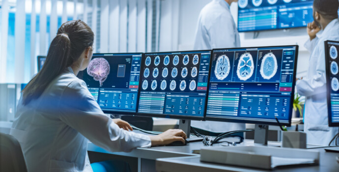 Team of Professional Scientists Work in the Brain Research Laboratory. Neurologists / Neuroscientists Surrounded by Monitors Showing CT, MRI Scans Having Discussions and Working on Personal Computers.