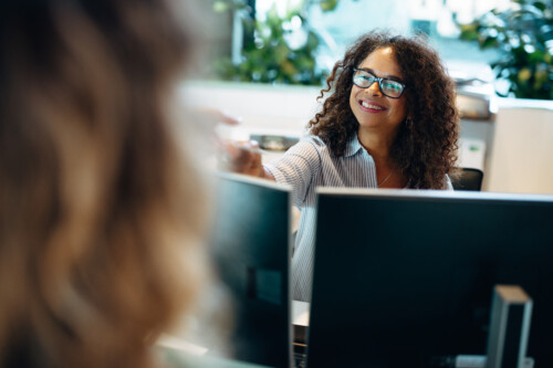 Receptionist assisting female visitor in office