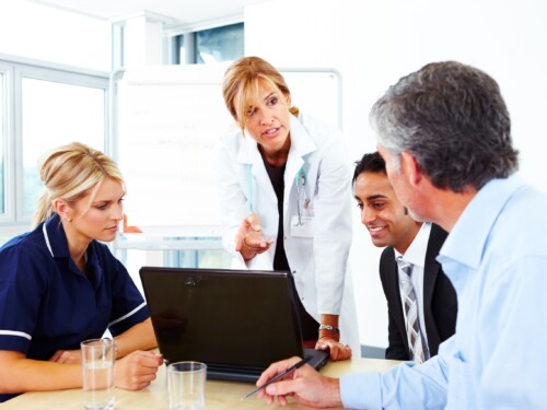 Female Doctor talking to businessmen and nurse in meeting