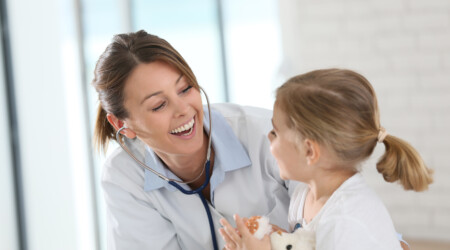 Doctor examining little girl with stethoscope