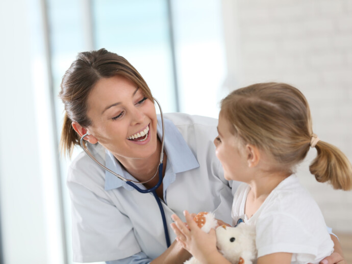 Doctor examining little girl with stethoscope