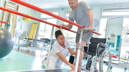 Occupational therapist helping patient to walk