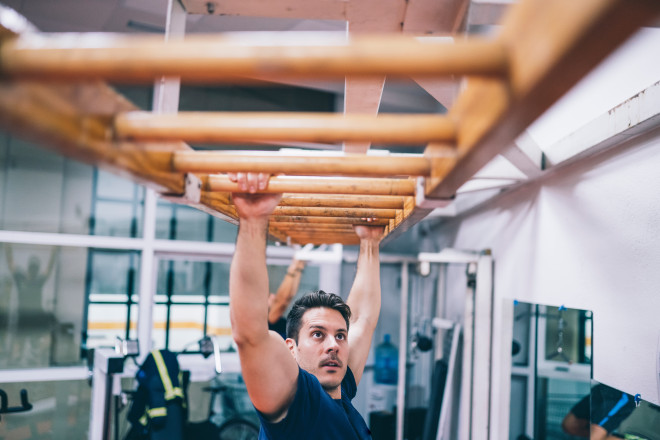 Fireman training on ladder with arms.