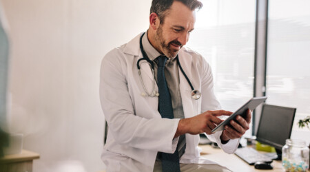 Doctor using digital tablet at his clinic