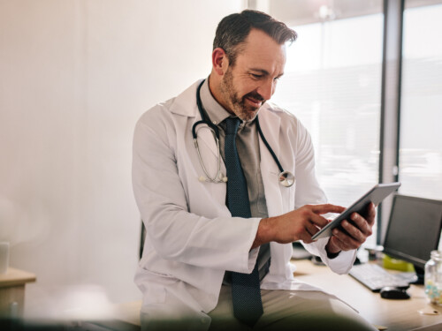 Doctor using digital tablet at his clinic