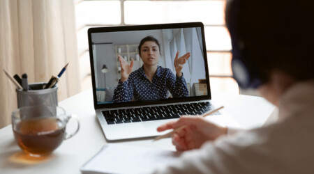 Millennial girl employee talk on video call with female colleague