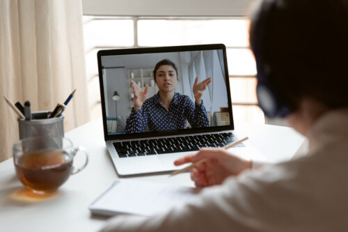 Millennial girl employee talk on video call with female colleague