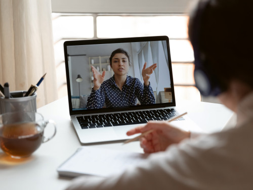 Millennial girl employee talk on video call with female colleague