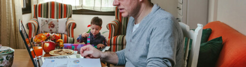 Father working at home while her son plays