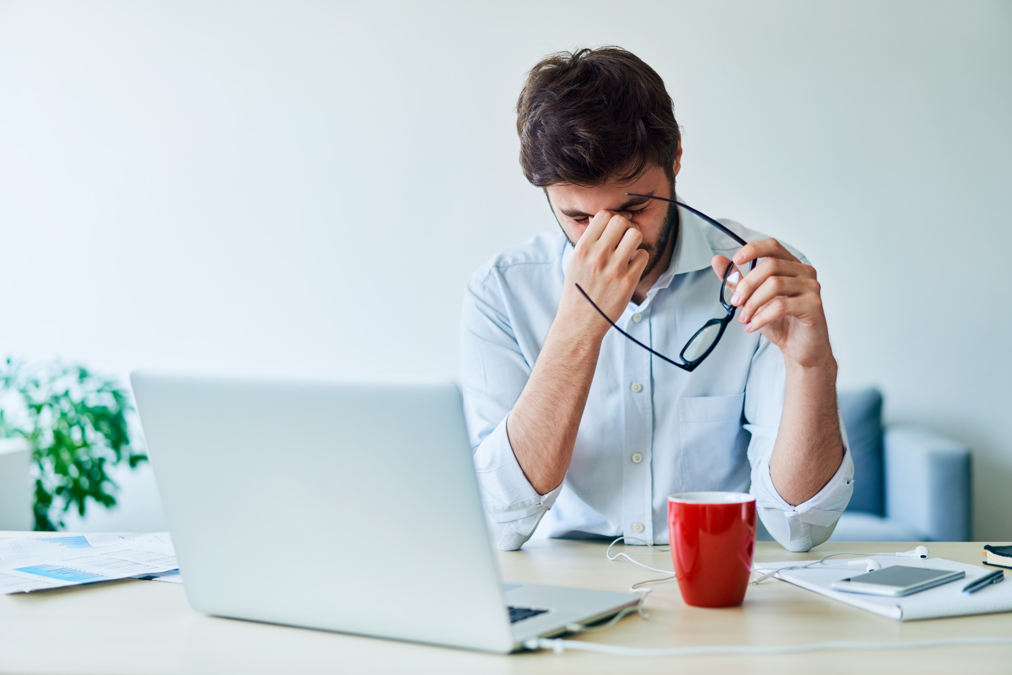 Young businessman having headache while working in home office