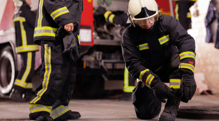 Professional firefighters with uniforms and protective helmets g
