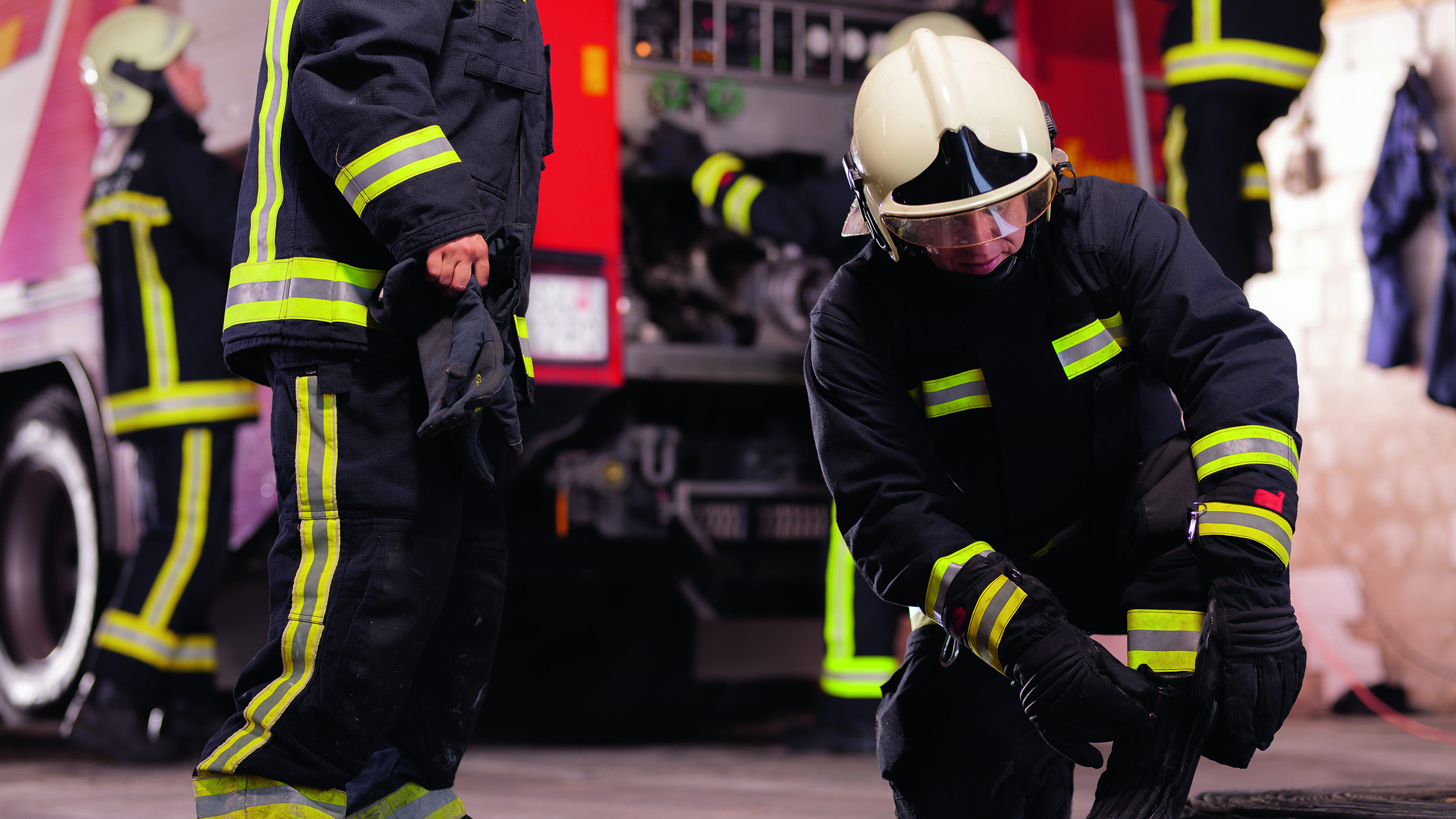 Professional firefighters with uniforms and protective helmets g