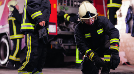 Professional firefighters with uniforms and protective helmets g