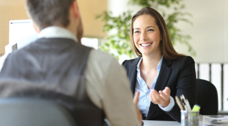 Happy executive coworkers laughing and talking at the office