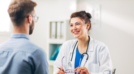 Woman Doctor talking to Patient at her Medical Office