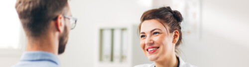 Woman Doctor talking to Patient at her Medical Office