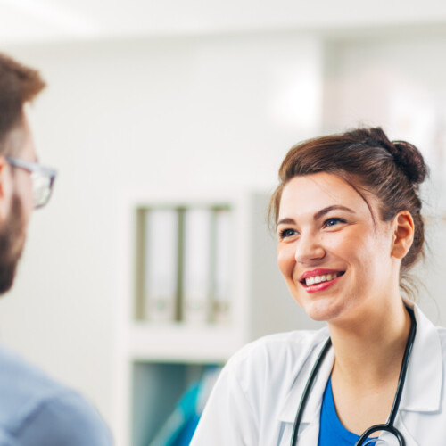 Woman Doctor talking to Patient at her Medical Office