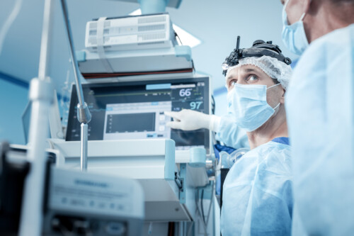 Serious male surgeon pointing at the screen