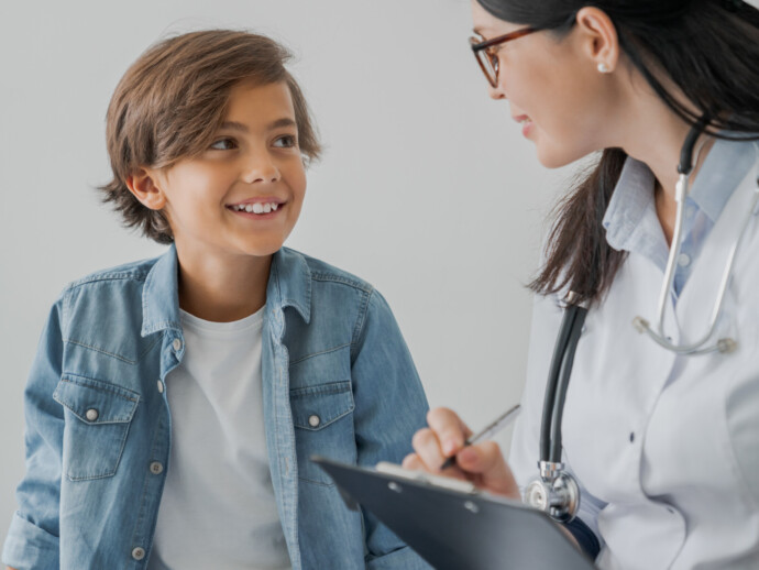 School boy and doctor have consultation in hospital room