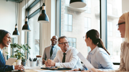 Diverse businesspeople laughing during a meeting around an offic