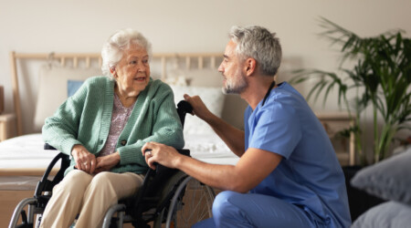 Caregiver doing regular check-up of senior woman in her home.