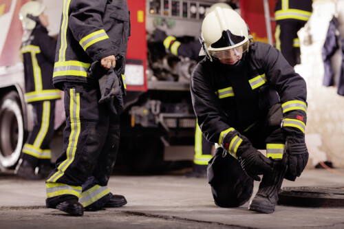 Professional firefighters with uniforms and protective helmets g