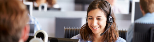 Young woman working in call centre, surrounded by colleagues