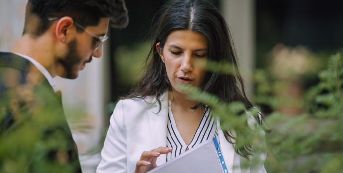 Businessman and businesswoman checking documents in the street