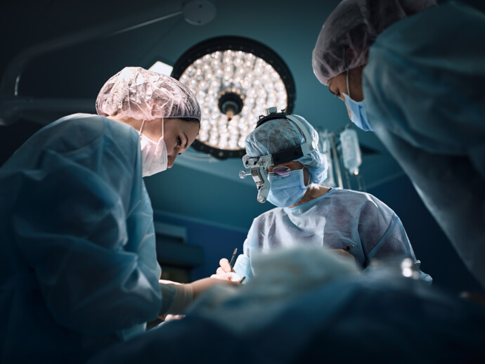 Medical team in the operating room, dark background. The theater of the operating room, an international team of professional doctors in a modern operating room are conducting an operation. Saving lives, modern medicine, blue blue light
