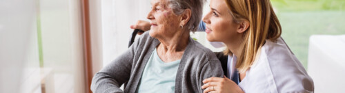 Health visitor and a senior woman during home visit.