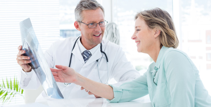 Doctor having conversation with his patient and holding xray