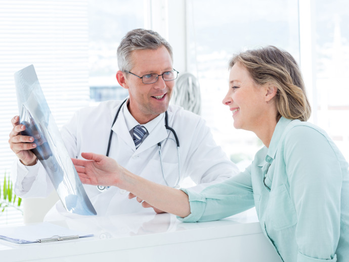 Doctor having conversation with his patient and holding xray