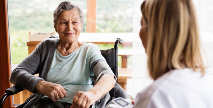 Health visitor and a senior woman during home visit.