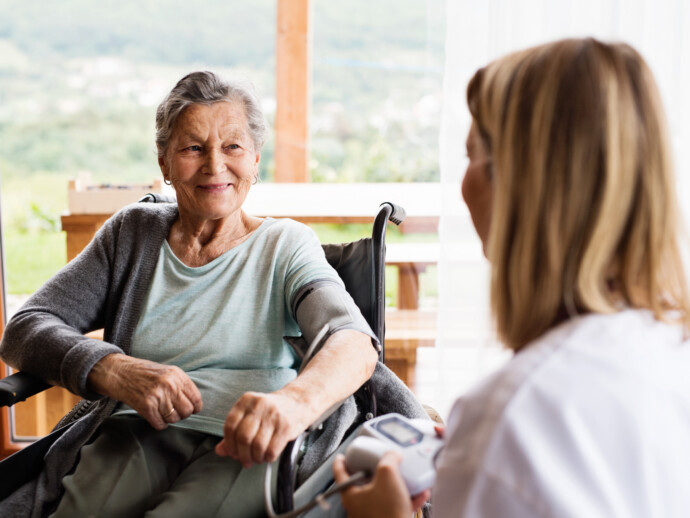 Health visitor and a senior woman during home visit.