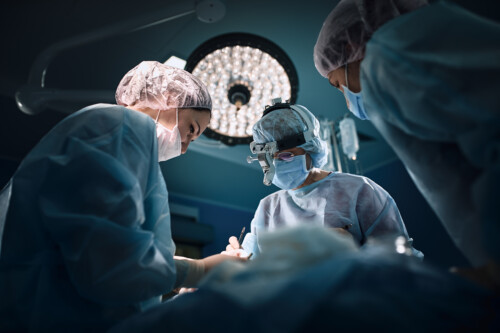 Medical team in the operating room, dark background. The theater of the operating room, an international team of professional doctors in a modern operating room are conducting an operation. Saving lives, modern medicine, blue blue light