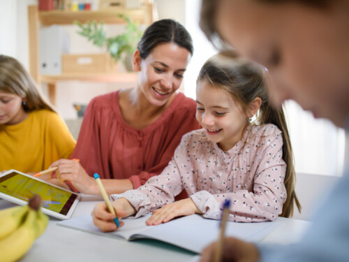 Group of homeschooling children with teacher studying indoors, coronavirus concept.