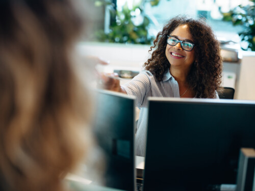 Receptionist assisting female visitor in office