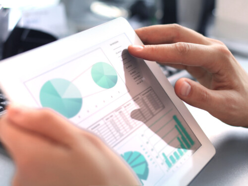 Business person analyzing financial statistics displayed on the tablet screen.