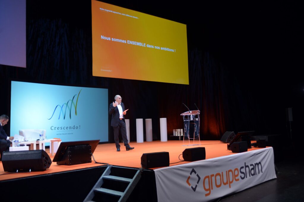 Intervenant sur scène lors d’une conférence du Groupe SHAM.