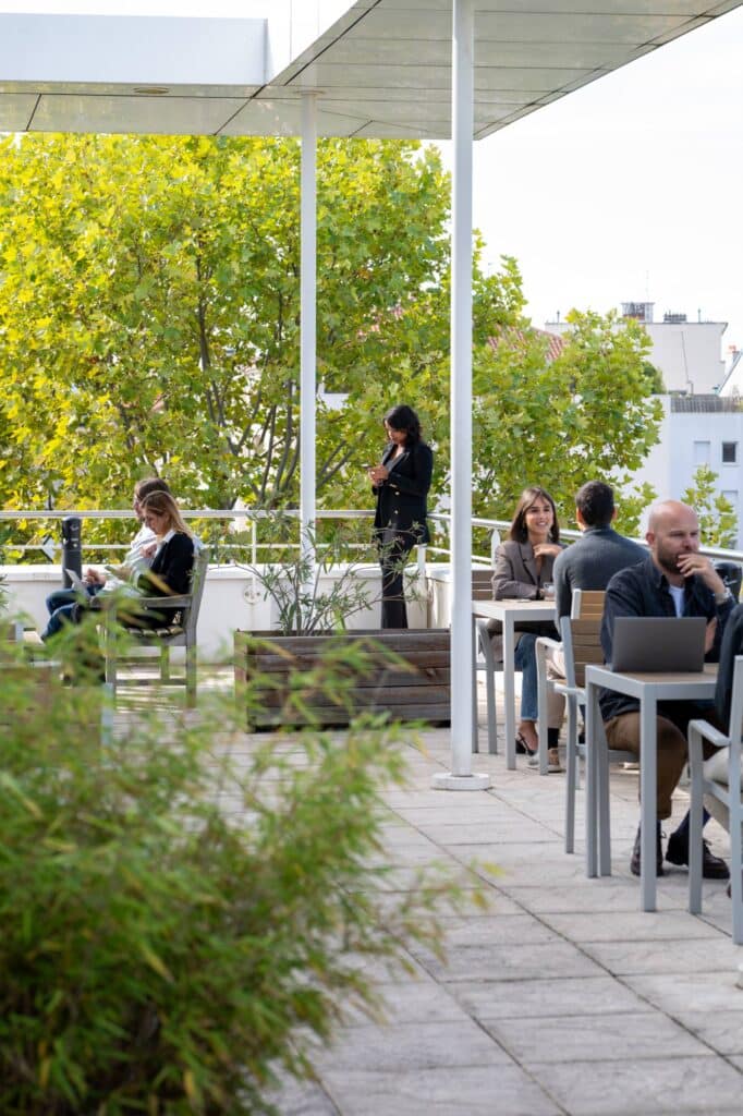 Collaborateurs travaillant et échangeant sur une terrasse végétalisée