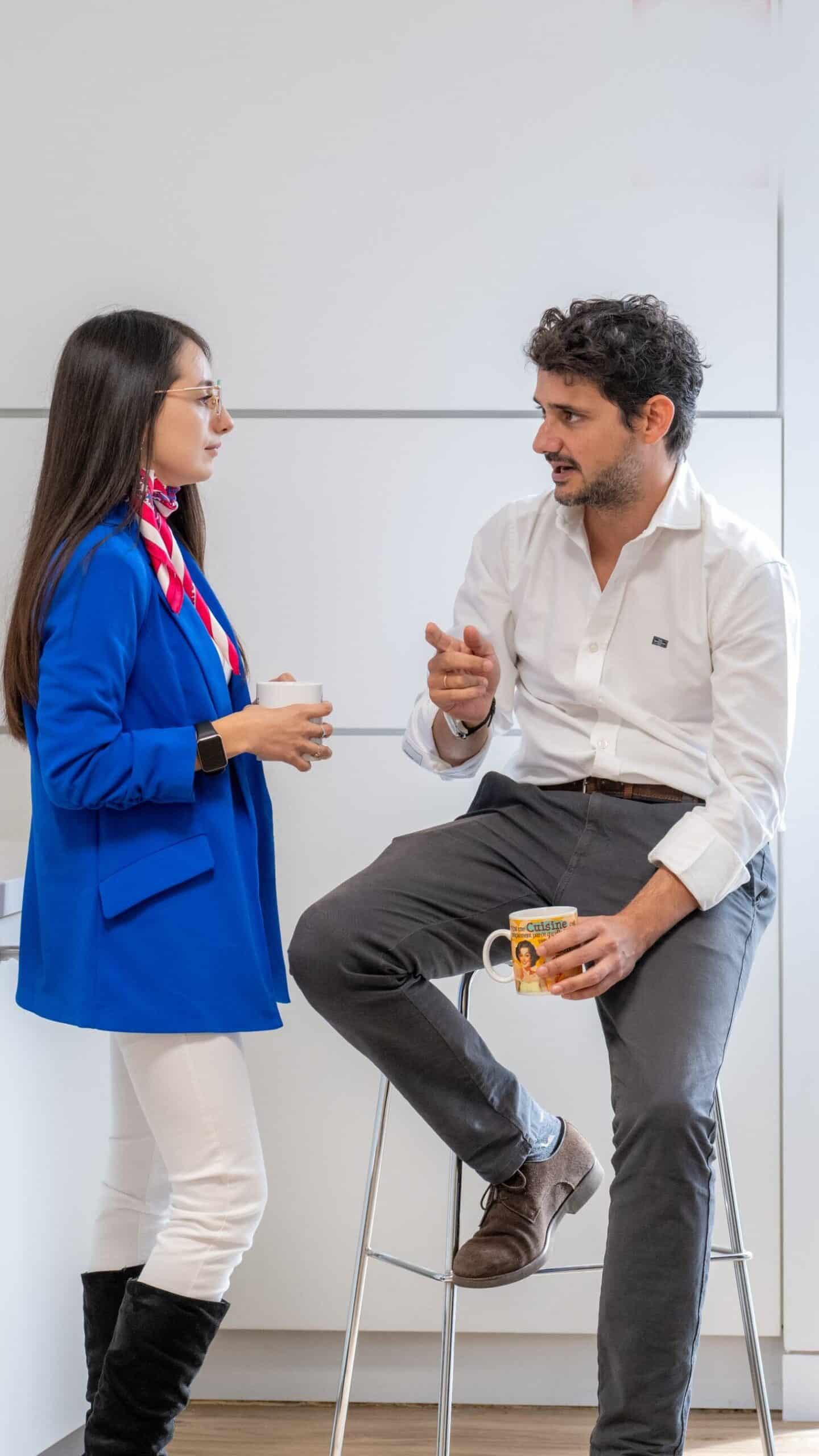 Colaboradores conversando en una zona de descanso mientras toman una bebida.