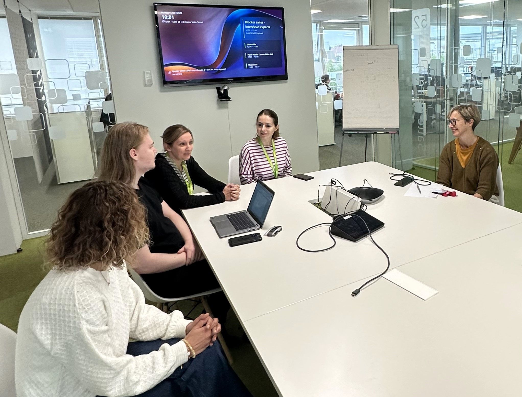 Arbeitsbesprechung mehrerer Mitarbeiterinnen an einem Konferenztisch.