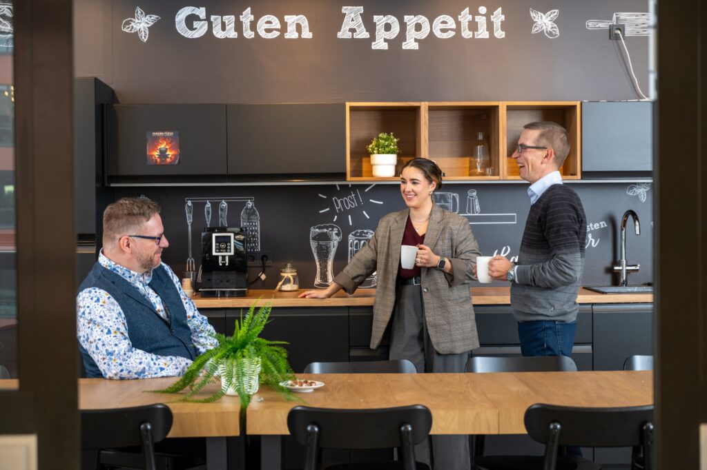 Trois collaborateurs discutant et prenant un café