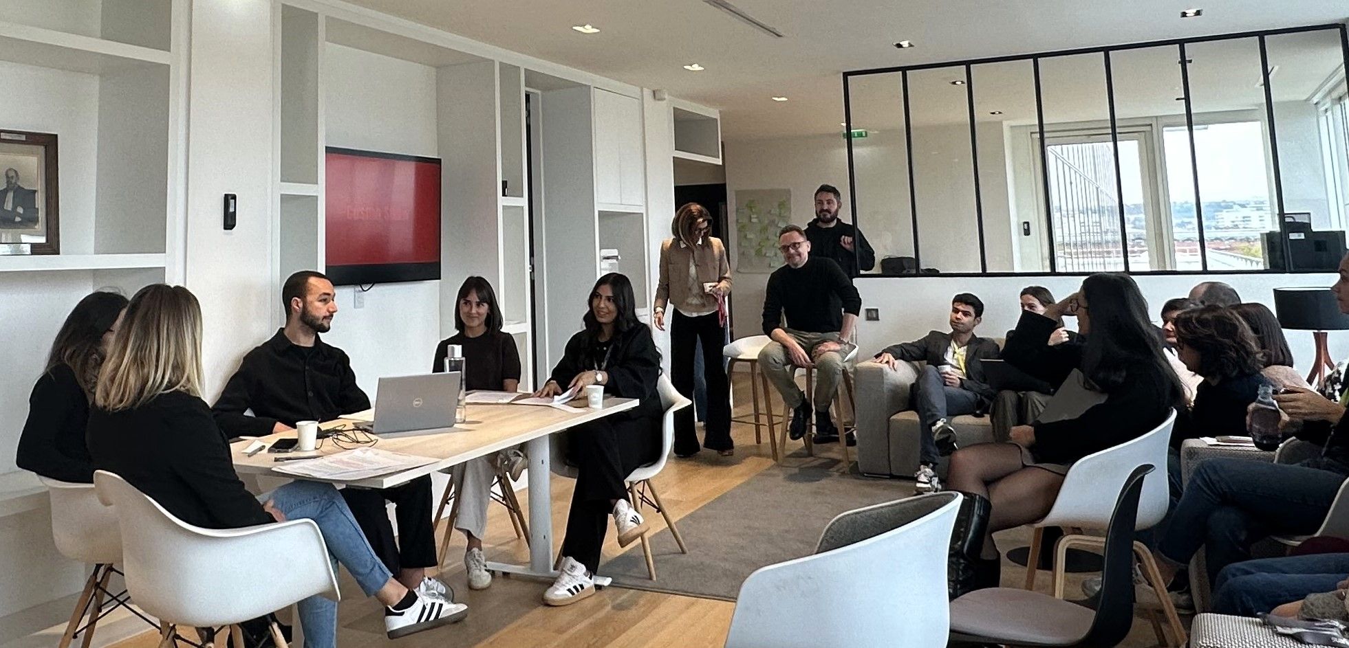 Présentation d’équipe dans un espace convivial, avec participants assis et debout