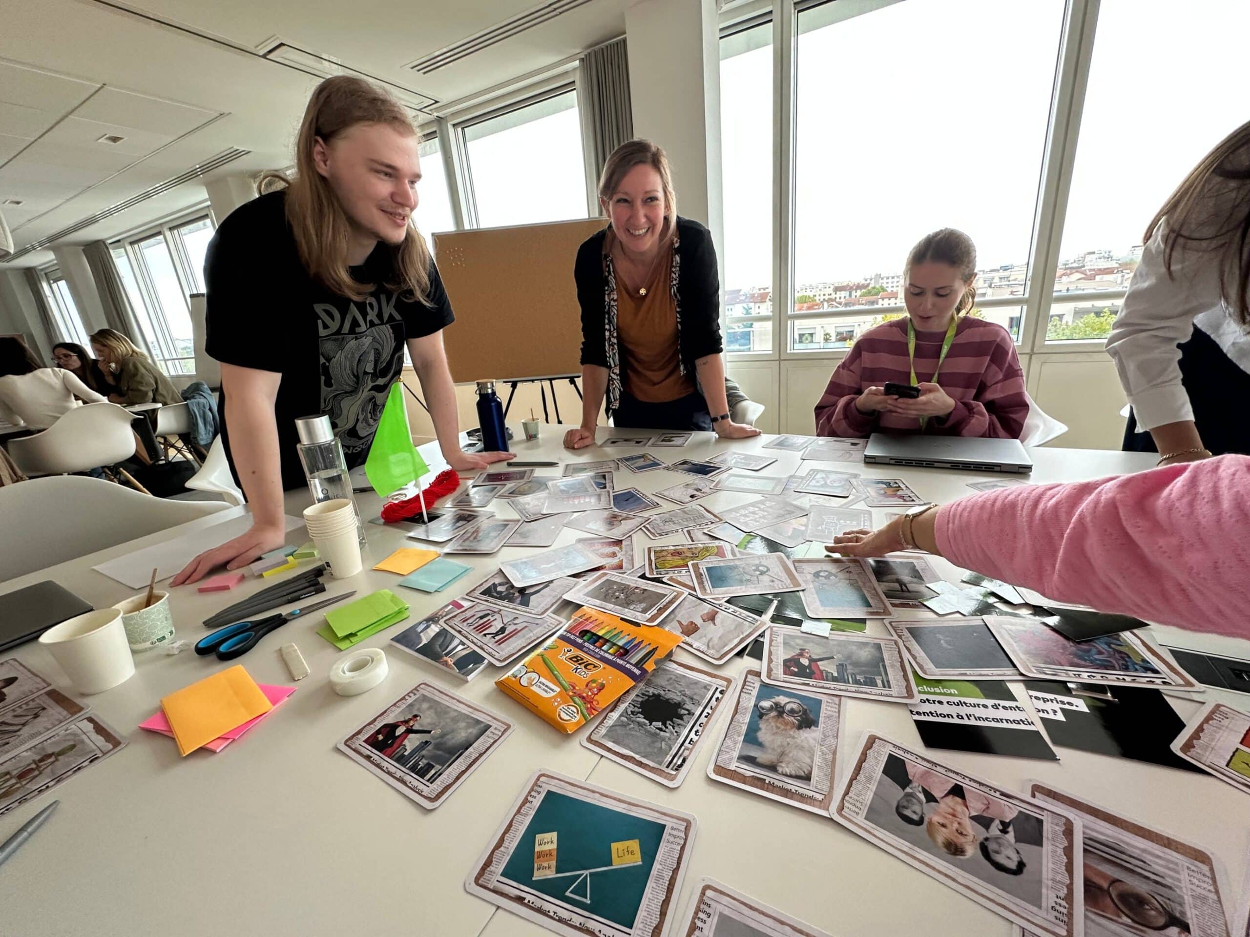 Taller colaborativo con participantes clasificando e intercambiando cartas extendidas sobre una mesa.